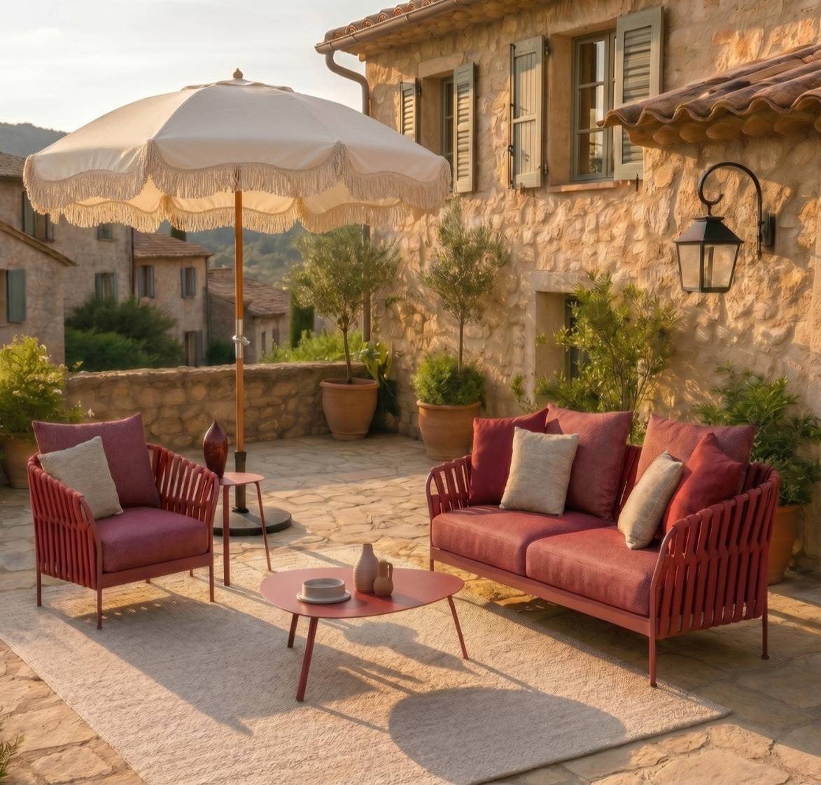 Terrasse en bois clair avec salon extérieur et lanternes, intégrée à un jardin provençal dans l’arrière-pays niçois.